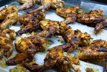 Hot and gold chicken wings with spicy sauce on oven tray