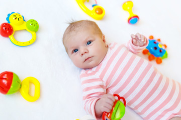 Cute baby girl playing with colorful rattle toys