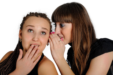 People, communication and friendship concept - smiling young women gossiping and whispering secrets