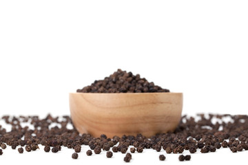 black peppercorns in wooden bowl