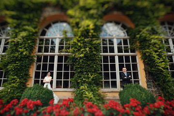 Elegant young couple near big beautiful windows of the castle