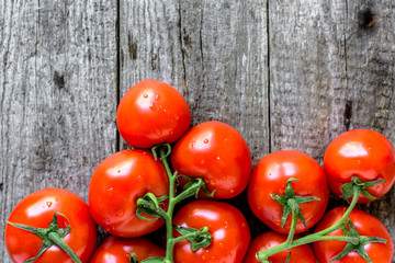 Top view of tomatoes, organic vegetables, fresh produce on wooden background