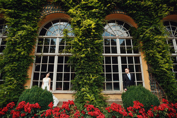 Fototapeta na wymiar Elegant young couple near big beautiful windows of the castle