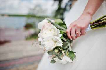 Elegance white wedding bouquet at hand of bride.