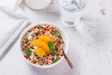 Healthy breakfast - plate of granola with orange slices, mint and seeds
