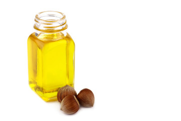 Hazelnut oil and hazelnuts on white background