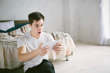 handsome man surfing on tablet. Guy talking with friends, video conference, skype, tablet. The...