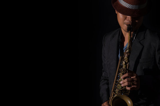 A saxophone player in a dark background