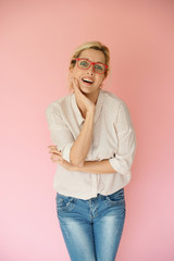 Funny blond woman with red eyeglasses standing on pink background