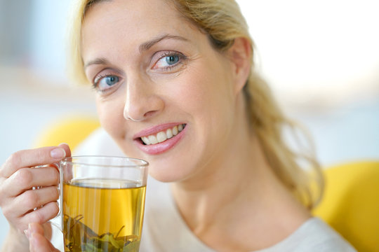 Portrait of blond woman drinking plants infusion