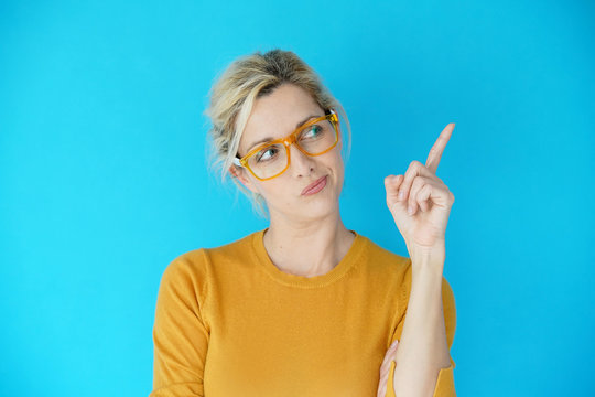 Portrait of blond woman with yellow eyeglasses pointing at message