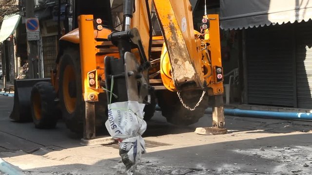 Hydraulic jack hammer is breaking concrete road