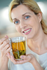 Portrait of blond woman drinking plants infusion