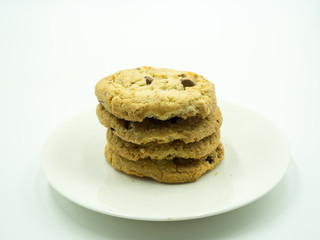 Chocolate chip cookies in white plate on white background