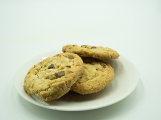 Chocolate chip cookies in white plate on white background