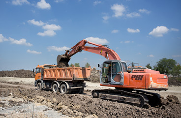 Excavator and truck working on road construction