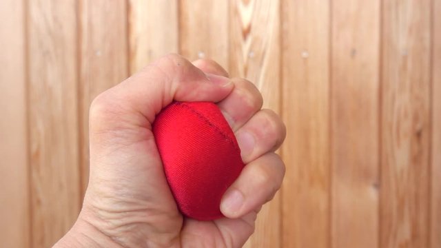 Hand squeeze red stress ball. Concept of anger, pressure and frustration. 