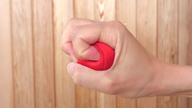 Hand squeeze red stress ball. Concept of anger, pressure and frustration. 