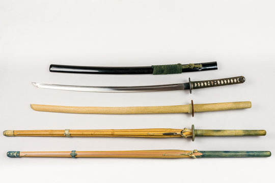 A collection of weapons for training, equipment for Japanese sport Iaido and Kendo. Wood, bamboo and steel sword arranged and displayed.