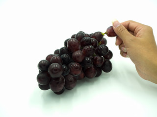 Woman's hand holding red grape on isolate white background