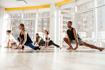 Multiethnic group of young people practicing yoga together