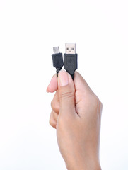 Hand holding USB to micro usb cable on white background