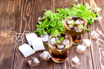 Ice tea with berry and fresh mint in glasses Wooden background