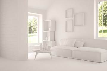 White room with sofa and green landscape in window. Scandinavian interior design
