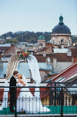 couple kissing on the roof near the arch