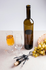 Obraz premium White wine and grapes. White wine in glass, bottle, corkscrew an