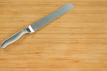 Steel kitchen knives on a wood board, top view