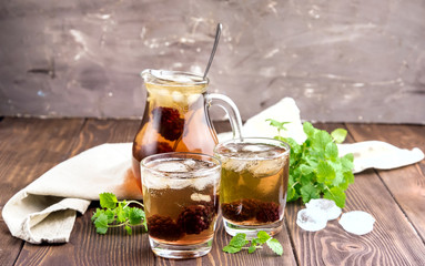 Ice tea with berry and fresh mint in glasses Wooden background