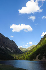 Fototapeta premium Panorama to Aigüestortes National Park in the Catalan Pyrenees. The main crest of Pyrenees forms a divide between France and Spain, with the microstate of Andorra sandwiched in between