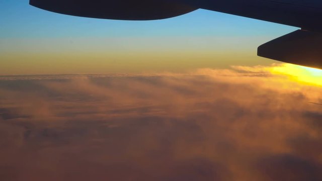Clouds and beautiful sunrise. View from the window of an airplane wing, clouds and a beautiful sunrise.