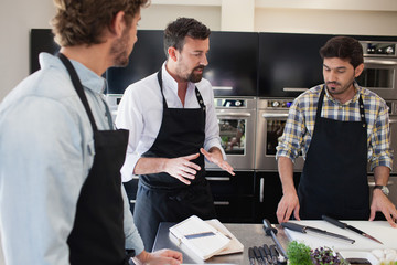 Chef teaching student in cooking class