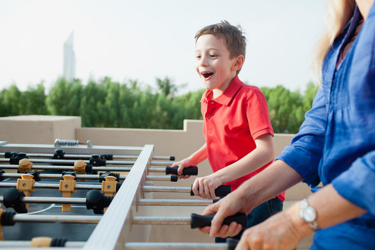 Mother and son playing foosball.