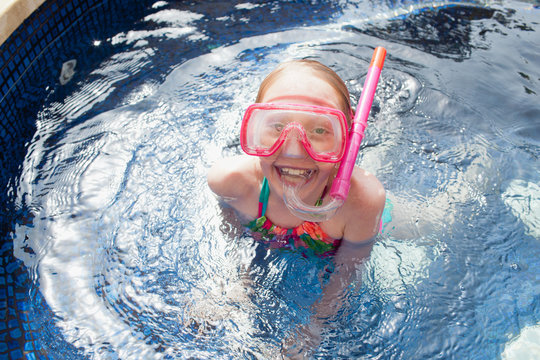 Portrait of girl with diving mask in swimming pool.