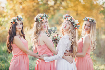 Bride with bridesmaids in pink dresses. A wedding in the fall.