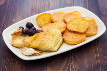 fried cod fish with potato on white dish