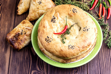 Turkish bread with sesame seeds on plate Wooden background Samosa Pepper
