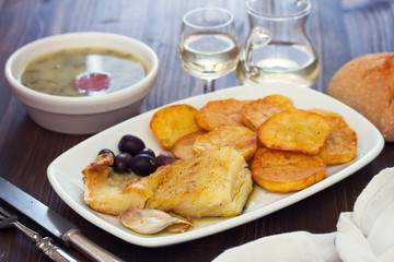 fried cod fish with potato on white dish