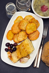 fried cod fish with potato on white dish