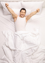 Obraz na płótnie Canvas Handsome guy stretching himself in bed