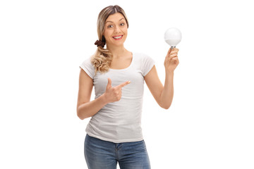 Happy woman holding a LED light bulb and pointing