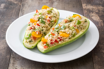 Stuffed zucchini with quinoa and vegetables on wooden background
