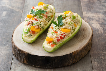 Stuffed zucchini with quinoa and vegetables on wooden background
