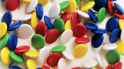 Colored push pins on a white background	