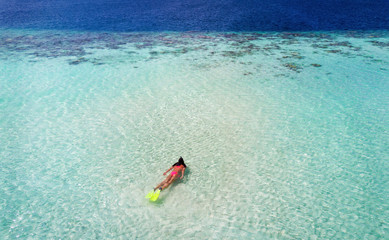 Luftaufnahme einer weiblichen Schnorchlerin am Korallenriff der Malediven