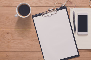 Office supplies and mobile phone at wood background