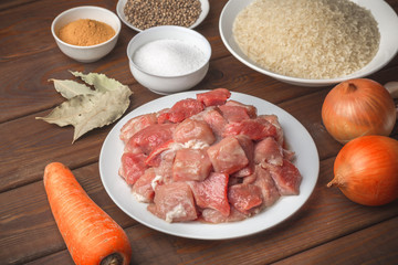 Cooking ingredients. Sliced raw meat, rice, spices, garlic, carrot, onion, bay 